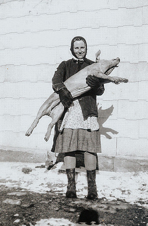 Grandma with pig they butchered 1945